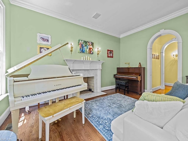 living area featuring hardwood / wood-style floors, a premium fireplace, and crown molding