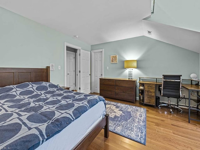 bedroom featuring light hardwood / wood-style floors and vaulted ceiling