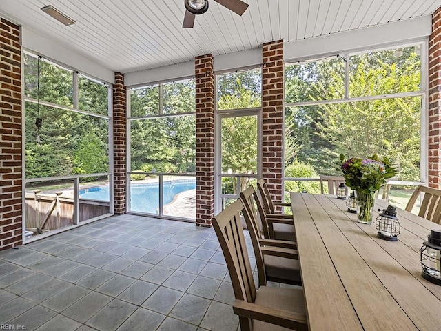 unfurnished sunroom featuring a wealth of natural light, wood ceiling, and ceiling fan