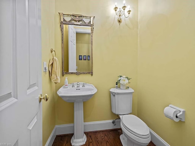 bathroom featuring wood-type flooring and toilet