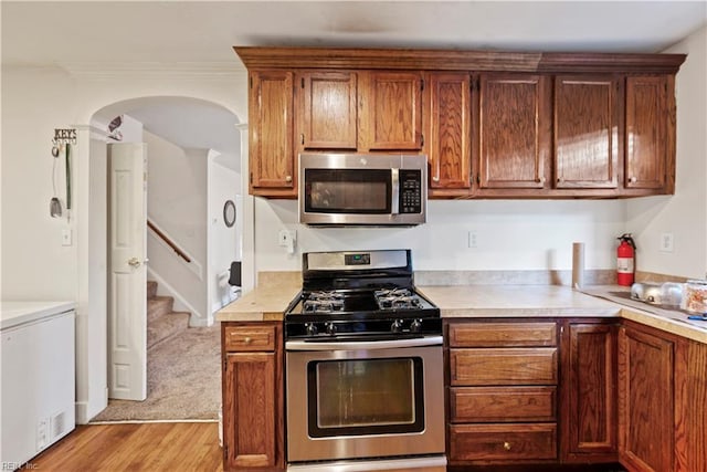 kitchen with stainless steel appliances and light hardwood / wood-style flooring