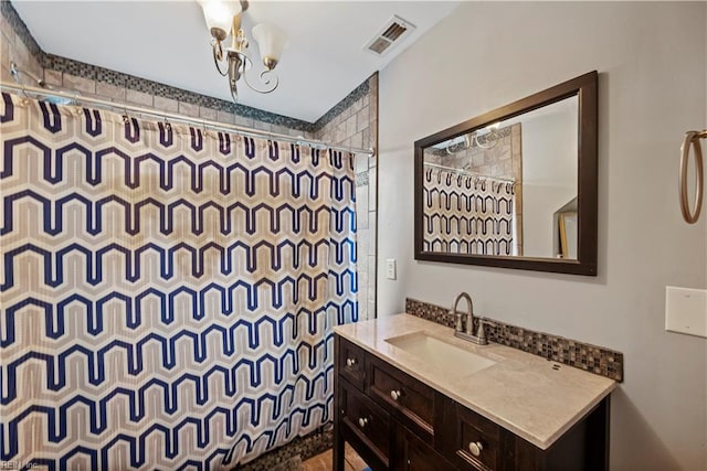 bathroom featuring vanity, a notable chandelier, and curtained shower