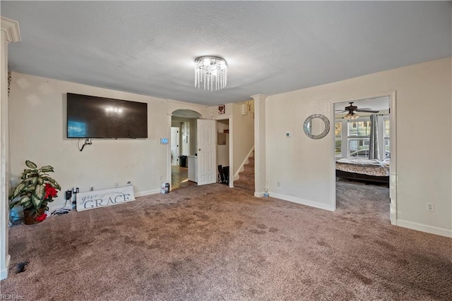 unfurnished living room featuring a textured ceiling, ceiling fan, and carpet floors