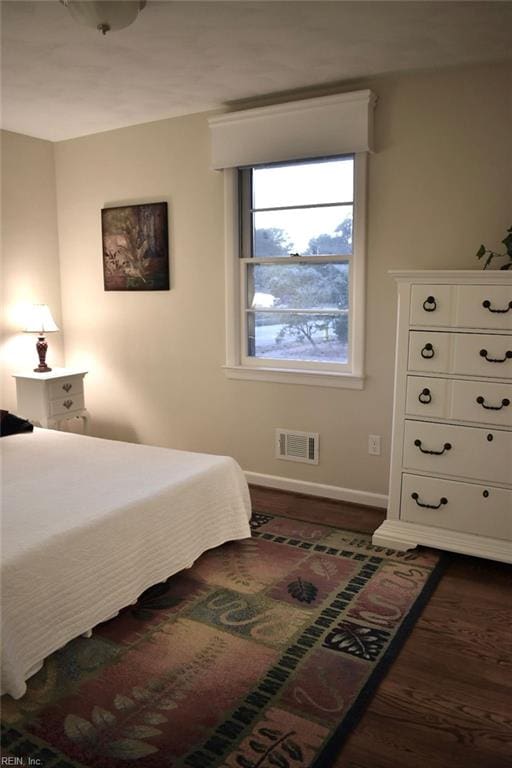 bedroom with dark wood-type flooring