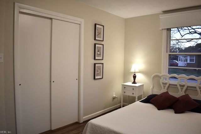 bedroom with dark wood-type flooring and a closet