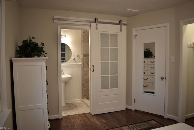 doorway to outside with dark hardwood / wood-style flooring and a barn door