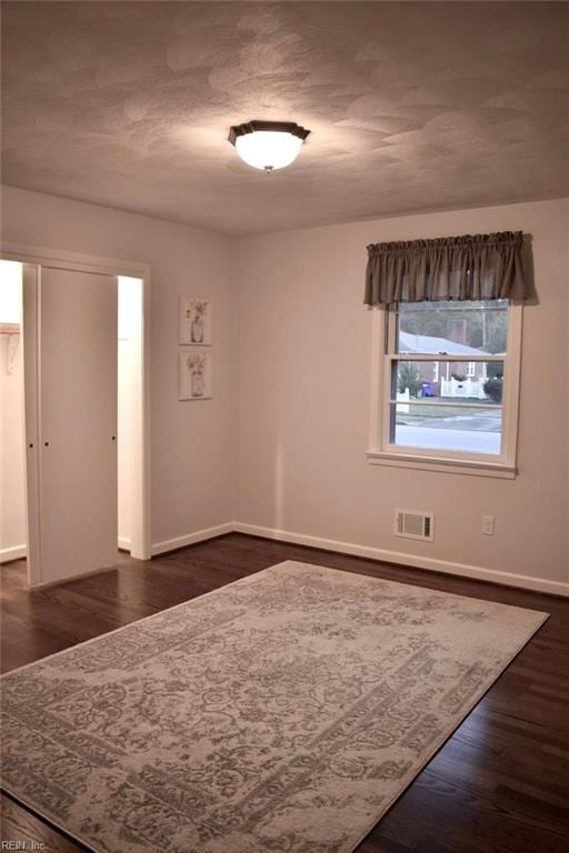 spare room with dark hardwood / wood-style flooring