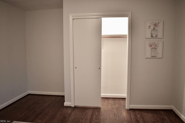 unfurnished bedroom with dark hardwood / wood-style floors and a closet