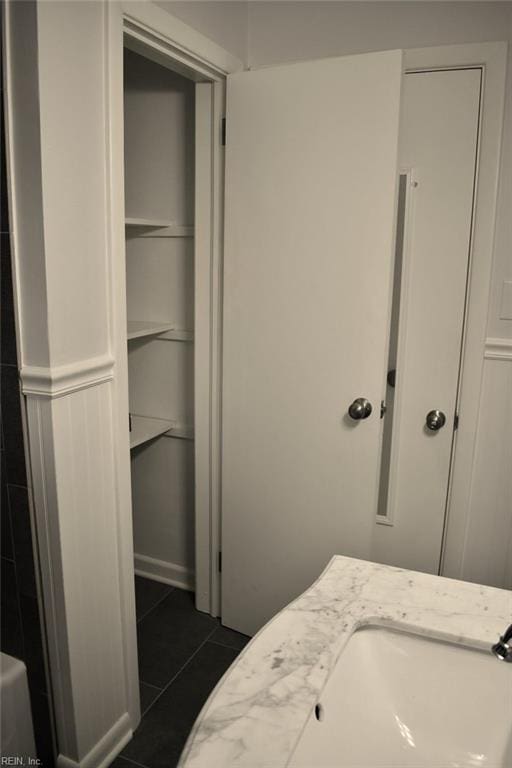 interior space featuring sink and dark tile patterned flooring