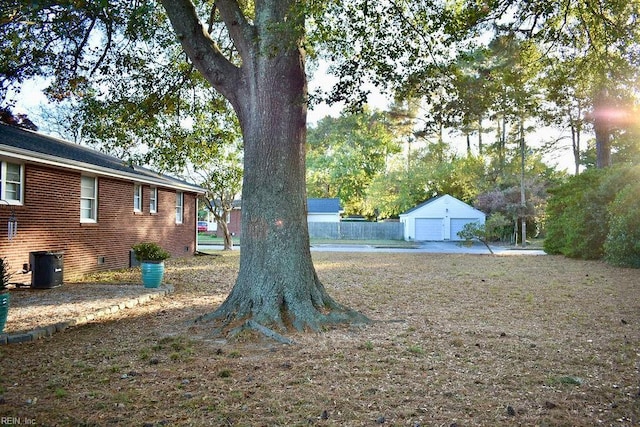 view of yard with a garage, an outdoor structure, and central AC unit