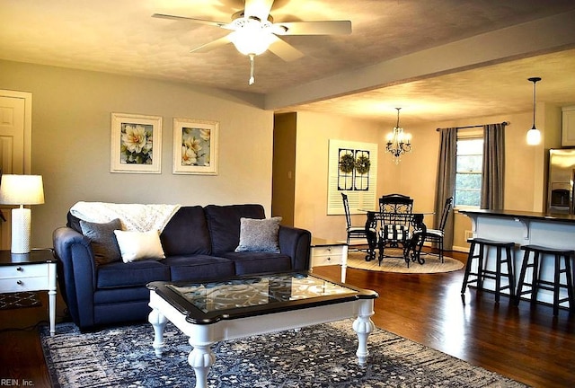 living room featuring beam ceiling, dark hardwood / wood-style floors, and ceiling fan with notable chandelier