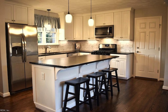 kitchen with stainless steel appliances, white cabinets, sink, dark hardwood / wood-style floors, and decorative light fixtures