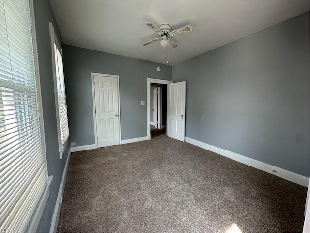 unfurnished bedroom featuring ceiling fan, a closet, and dark carpet