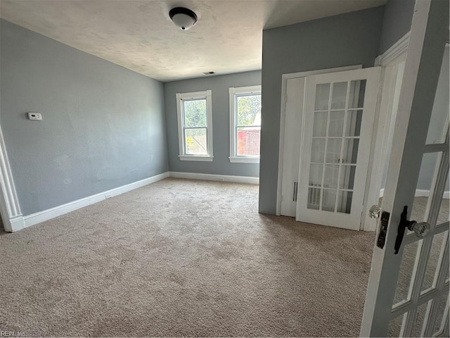 spare room featuring carpet and a textured ceiling