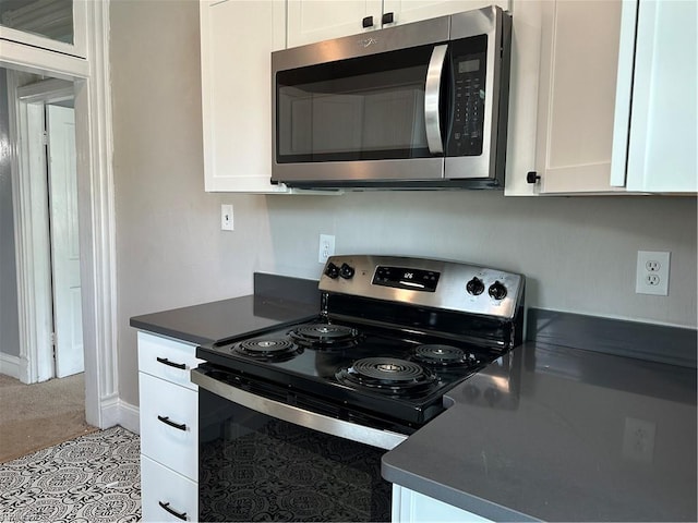 kitchen with stainless steel appliances, white cabinets, and light tile patterned floors