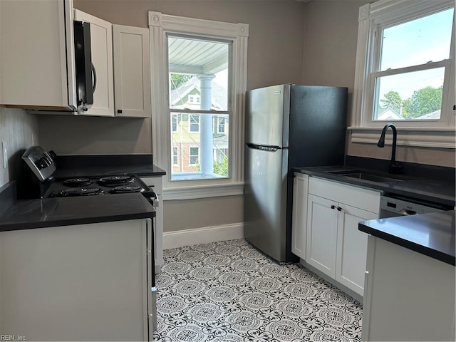 kitchen featuring light tile patterned flooring, white cabinetry, sink, and appliances with stainless steel finishes