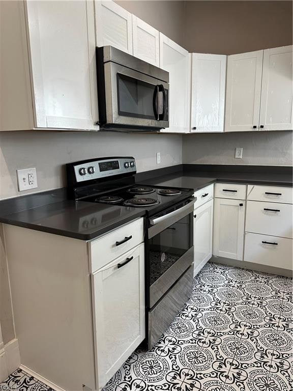 kitchen featuring white cabinetry, appliances with stainless steel finishes, and light tile patterned floors