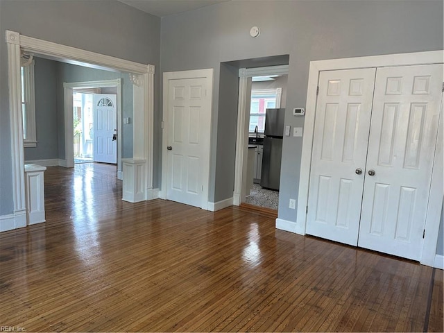 interior space with dark hardwood / wood-style floors and stainless steel refrigerator