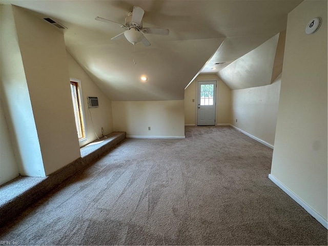 additional living space featuring ceiling fan, a wall unit AC, light colored carpet, and lofted ceiling