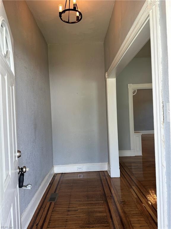 interior space with a notable chandelier and dark hardwood / wood-style floors