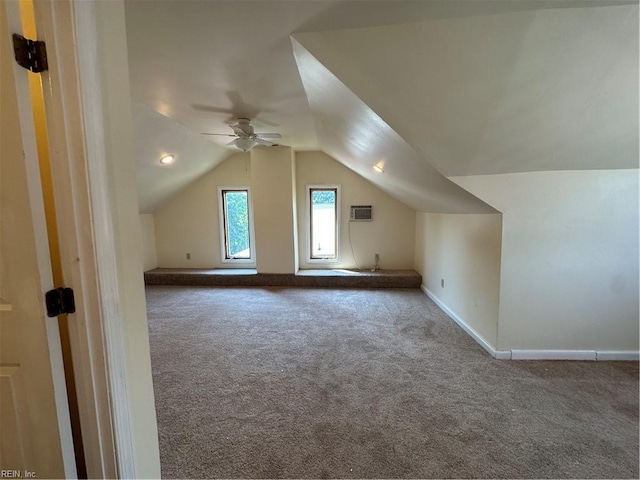 additional living space featuring ceiling fan, a wall mounted air conditioner, lofted ceiling, and carpet