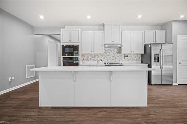 kitchen featuring white cabinetry, an island with sink, dark hardwood / wood-style floors, and stainless steel appliances