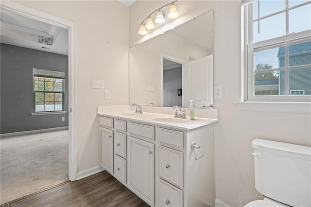 bathroom with hardwood / wood-style floors, vanity, and toilet