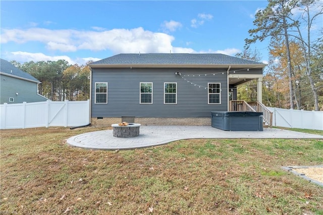 rear view of property featuring a patio area, a lawn, and a fire pit