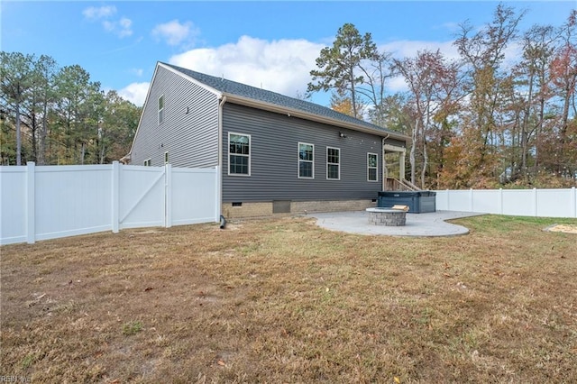 rear view of property with an outdoor fire pit, a yard, and a patio area