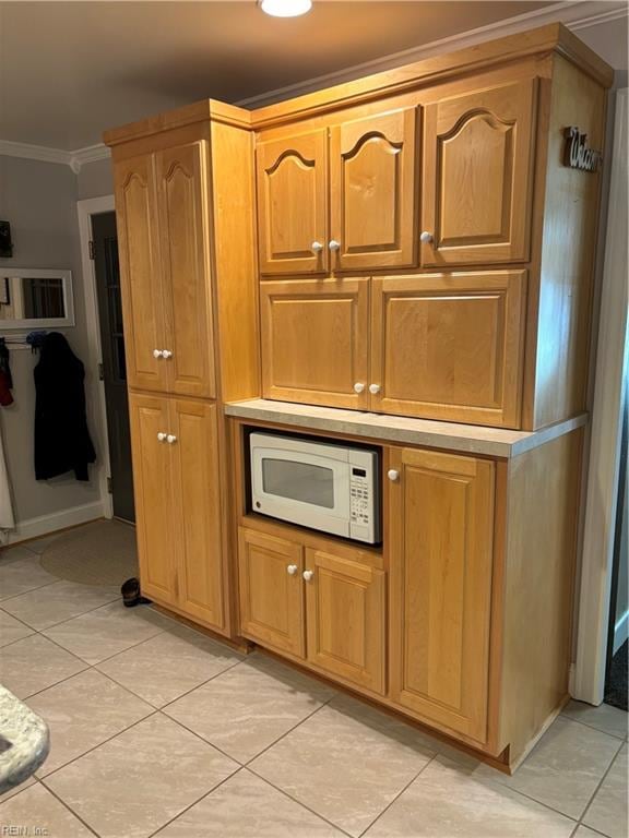 kitchen featuring crown molding and light tile patterned floors