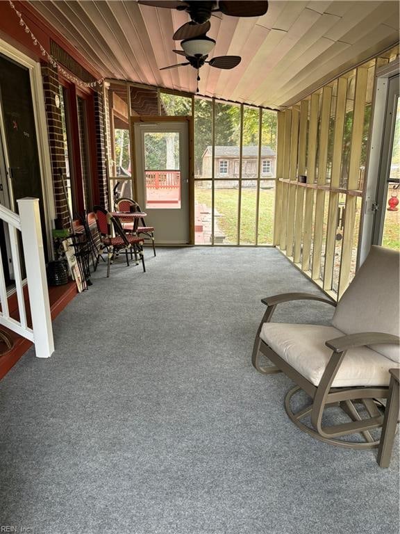 sunroom / solarium with ceiling fan, wooden ceiling, and vaulted ceiling