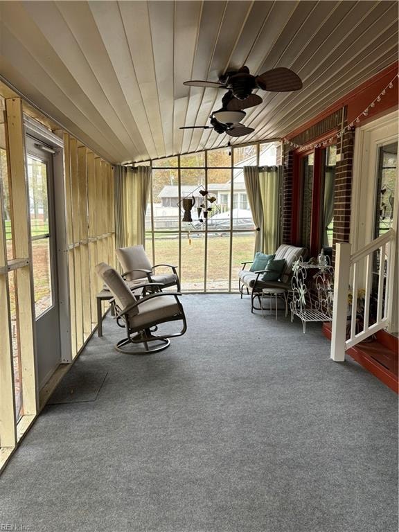 unfurnished sunroom with ceiling fan and wooden ceiling