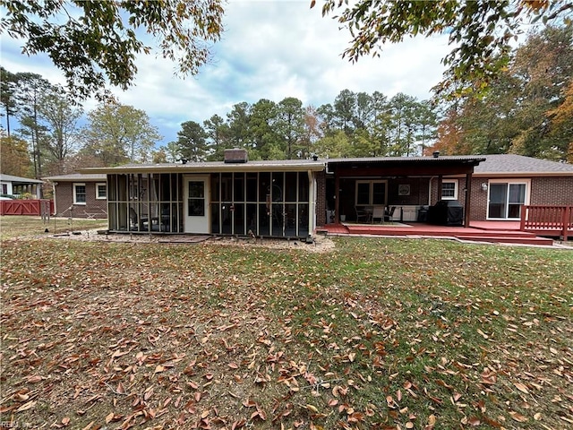 rear view of house featuring a lawn, a patio area, and a sunroom