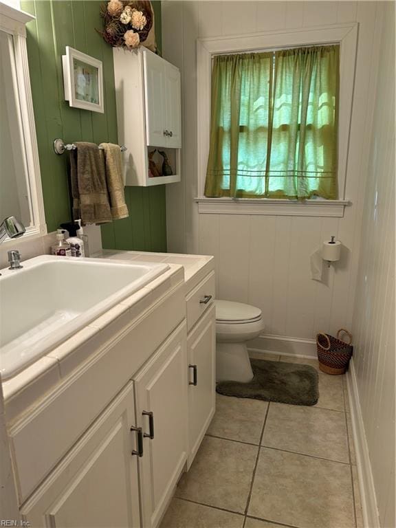 bathroom with tile patterned flooring, vanity, and toilet