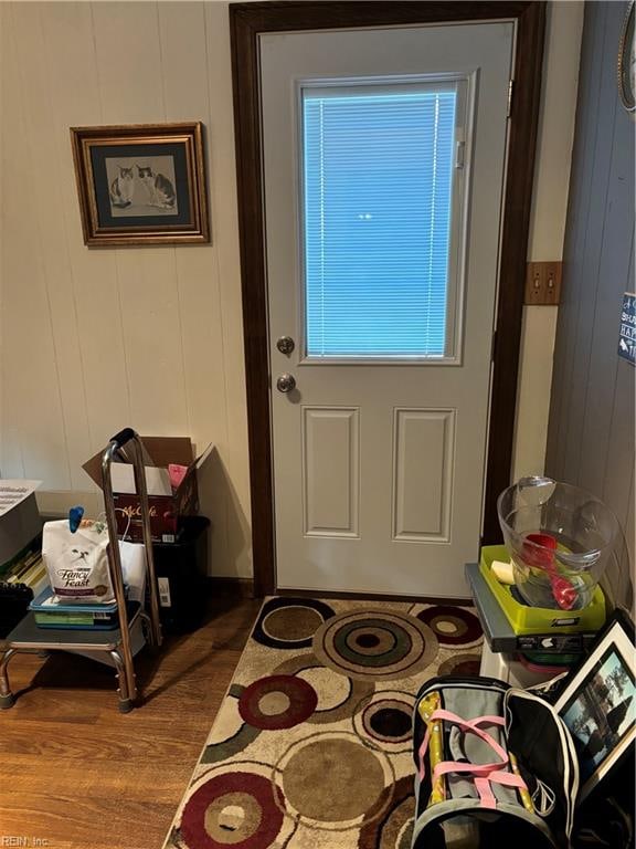 doorway featuring hardwood / wood-style floors and wood walls