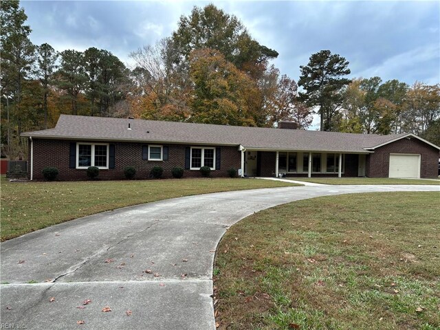 single story home featuring a garage and a front lawn