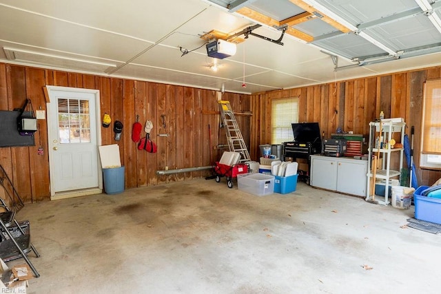 garage with a garage door opener and wood walls