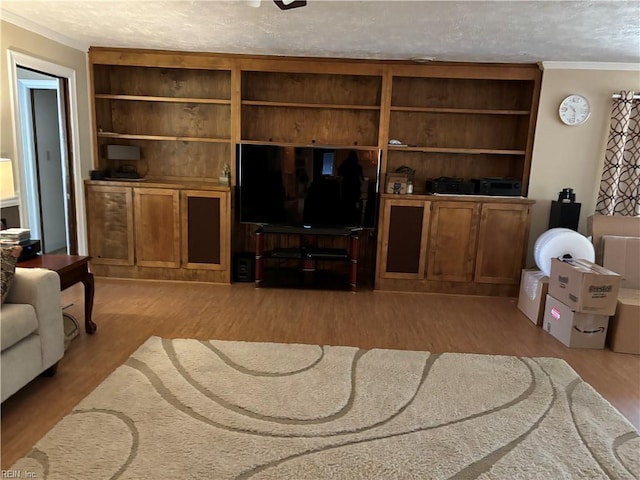 living room with crown molding, a textured ceiling, and light hardwood / wood-style flooring