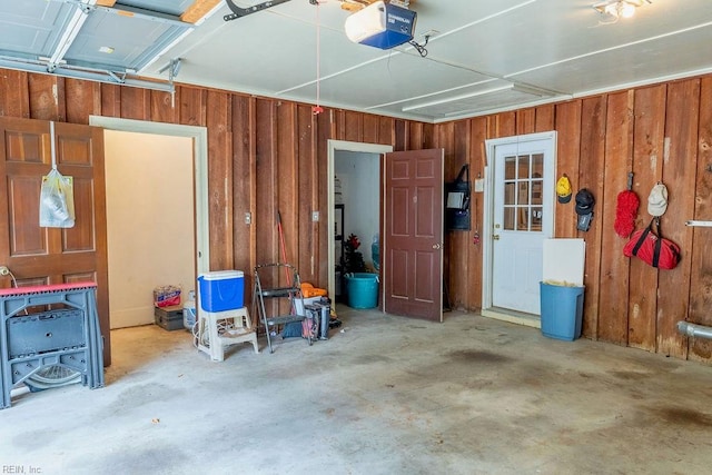 garage with wood walls and a garage door opener