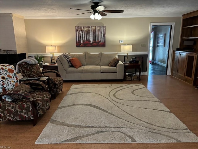 living room with ceiling fan, crown molding, a textured ceiling, and hardwood / wood-style flooring