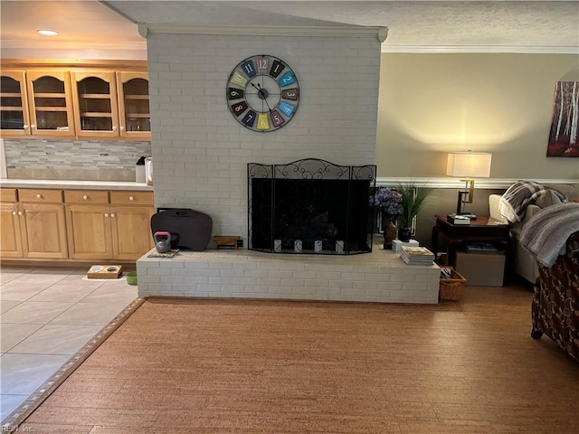 living room with a fireplace, light wood-type flooring, and crown molding