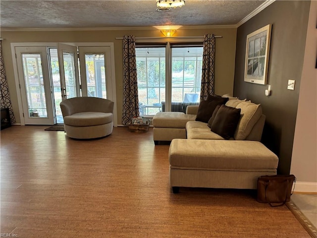 living room featuring a textured ceiling, hardwood / wood-style flooring, crown molding, and a healthy amount of sunlight