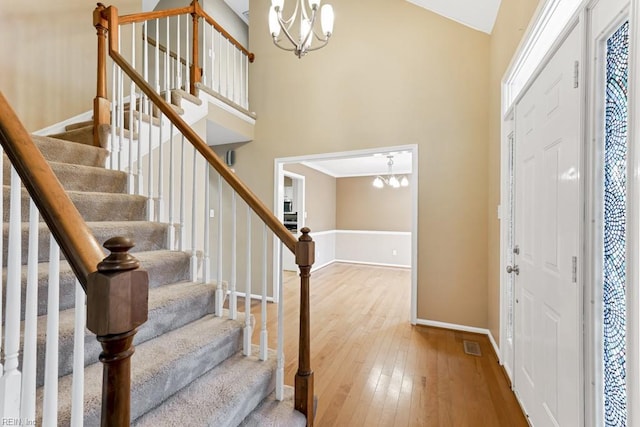 foyer with hardwood / wood-style floors, a chandelier, and high vaulted ceiling