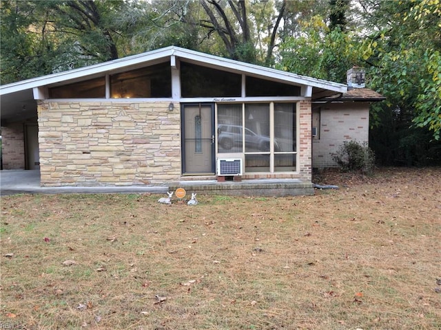 exterior space featuring a sunroom and a yard