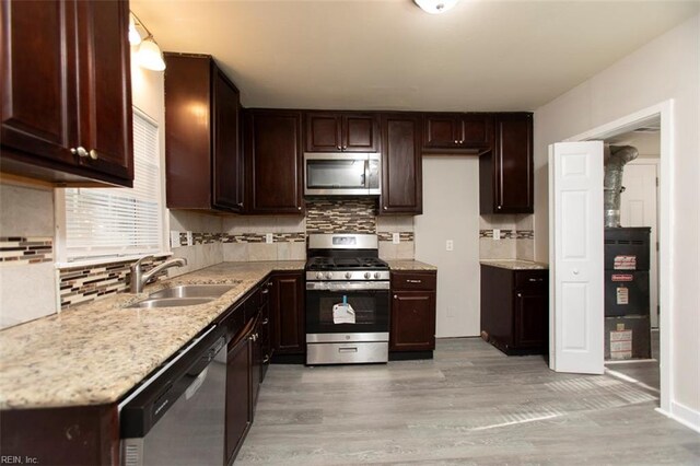 228 Libby St, Hampton, VA 23663 - kitchen with appliances with stainless steel finishes, a sink, decorative backsplash, light wood finished floors, and dark brown cabinets