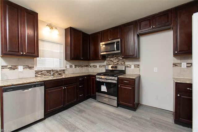 228 Libby St, Hampton, VA 23663 - kitchen with appliances with stainless steel finishes, a sink, tasteful backsplash, light wood-style floors, and light stone counters