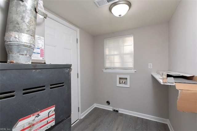 clothes washing area featuring dark wood-type flooring, washer hookup, and heating unit