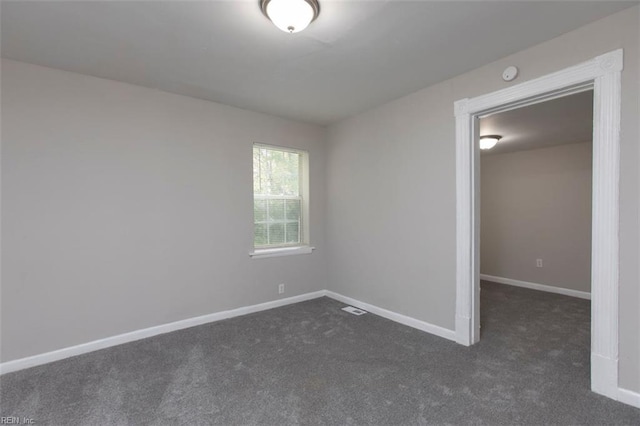 unfurnished bedroom featuring dark colored carpet and a spacious closet