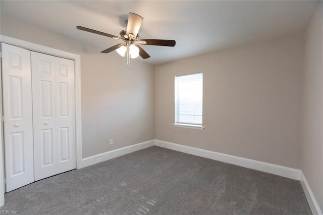 unfurnished bedroom featuring dark colored carpet, ceiling fan, and a closet