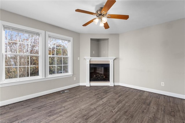 unfurnished living room featuring dark hardwood / wood-style flooring and ceiling fan